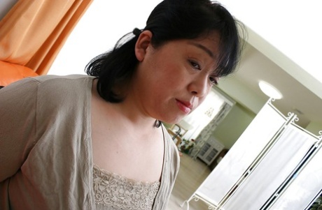 Brunette mature Eiko Imamiya undresses her skirt and shows her Asian ass